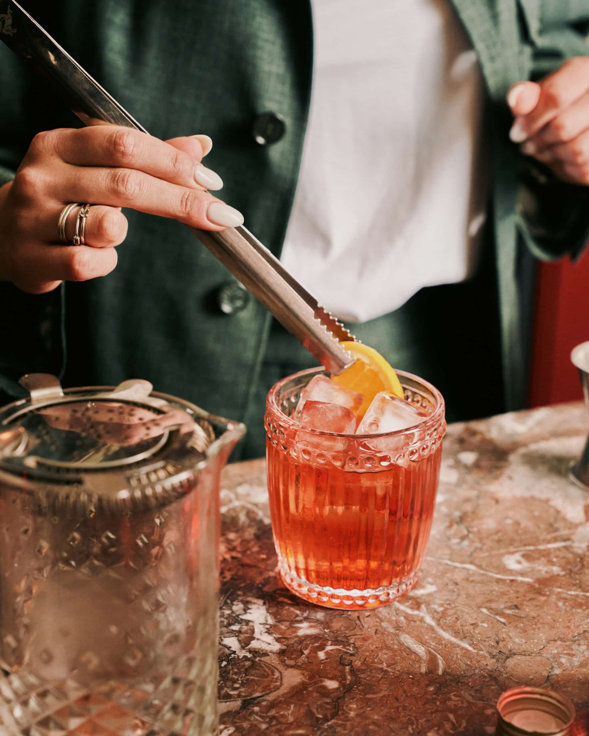 Waitress in green outfit preparing a Aperol Spritz