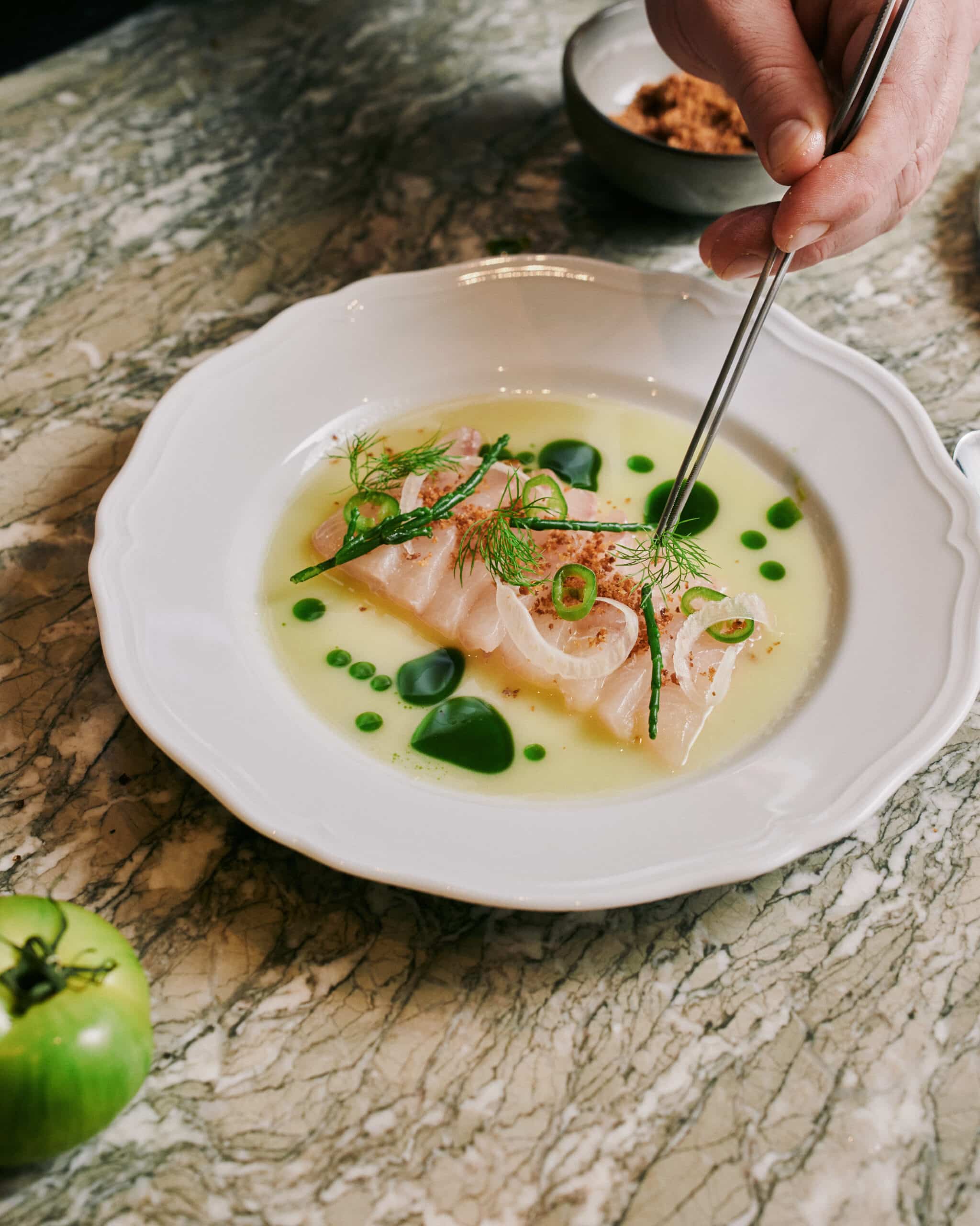 Chef putting a finish in touch to a ceviche at Trattoria Graziella